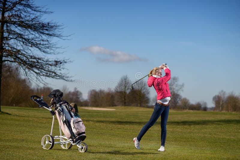 Young female golfer playing on the fairway royalty free stock photography Young female golfer playing on the fairway royalty free stock photography