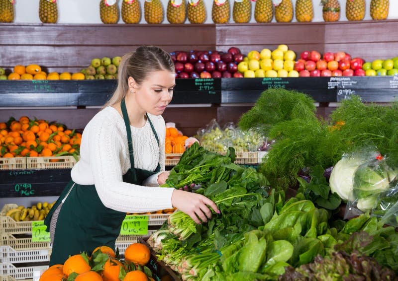 Salesgirl arranging greens