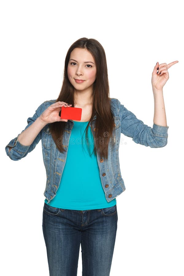 Young female holding blank credit card and pointing to the side