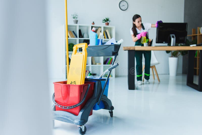 young female janitor cleaning office with various stock photo young female janitor cleaning office with various stock photo
