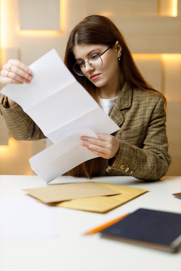 A Young Female Lawyer Looks through the Mail at the Workplace