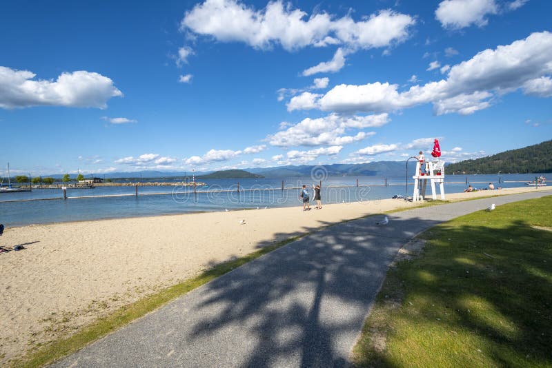 A young female lifeguard stands on duty at a lifeguard station along the sandy city beach of Lake Pend Oreille at Sandpoint, Idaho stock images A young female lifeguard stands on duty at a lifeguard station along the sandy city beach of Lake Pend Oreille at Sandpoint, Idaho stock images