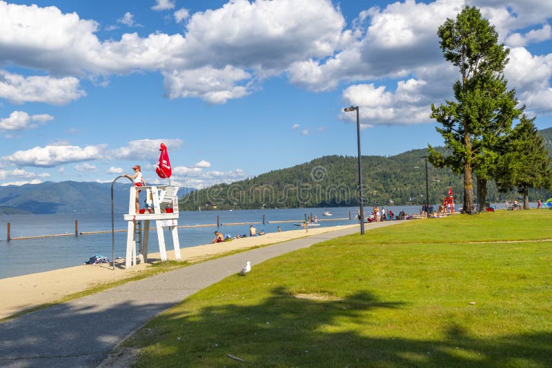 A young female lifeguard stands on duty at a lifeguard station along the sandy city beach at Sandpoint, Idaho, on Lake Pend Oreill stock photos A young female lifeguard stands on duty at a lifeguard station along the sandy city beach at Sandpoint, Idaho, on Lake Pend Oreill stock photos