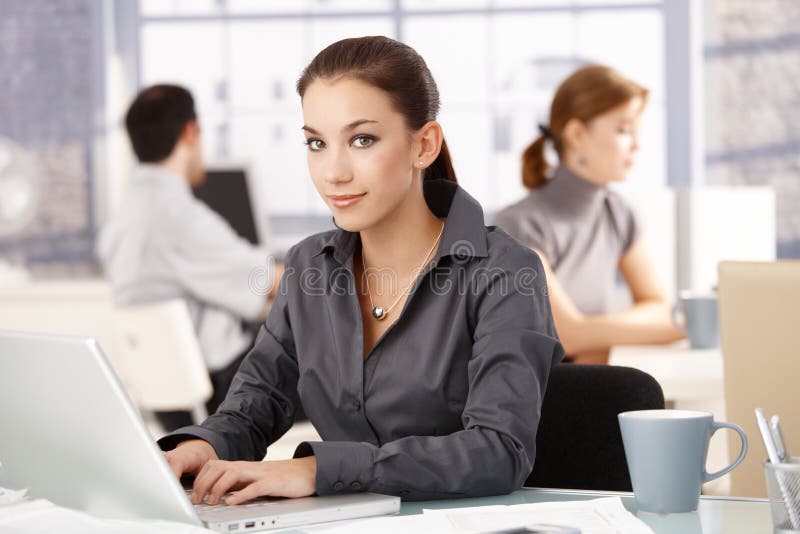 Young female in office colleagues working behind stock photography