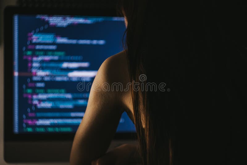 Young female programmer writes program code on a computer. stock photography
