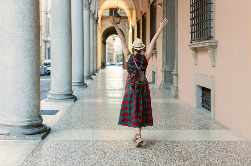 Studentă tânără îmbrăcată ocazional cu brațe deschise în faimoasele galerii arcuite din orașul Bologna din Italia. bologna royalty free stock images