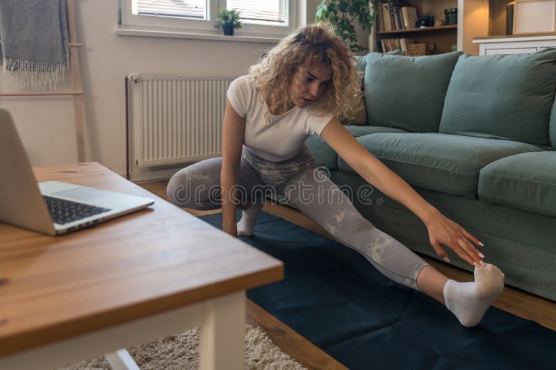 young-female-student-exercising-at-home-to-relieve-back-pain-from-long
