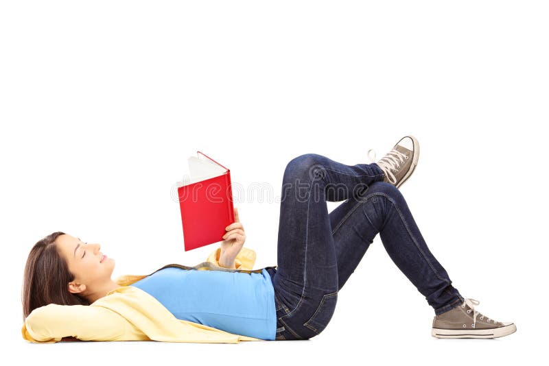 Young female student lying on a floor and reading a novel stock images Young female student lying on a floor and reading a novel stock images