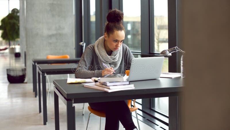 Young female student taking notes for her study