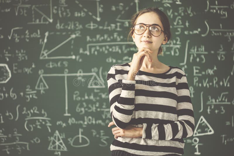 Young female student thinking in front of classroom board royalty free stock photo