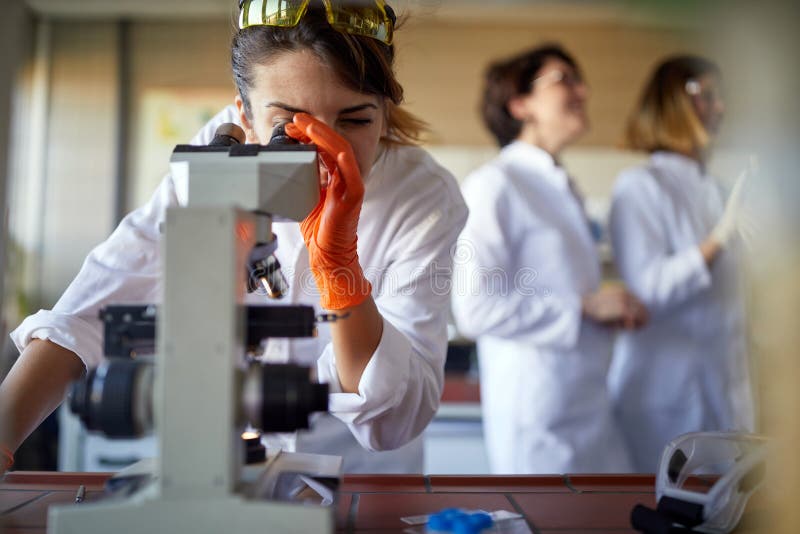 Young female student working at the microscope in the university laboratory. Science, chemistry, lab, people royalty free stock image
