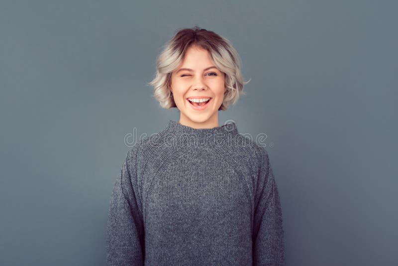 Giovane una donna logorante grande un maglione Contento facciale espressione battito di ciglia contento divertirsi.