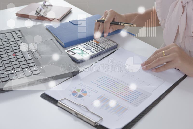 Young finance market analyst working at office on laptop while sitting at white table.Businessman analyze document. And the calculator in hands.Graphs and royalty free stock images Young finance market analyst working at office on laptop while sitting at white table.Businessman analyze document. And the calculator in hands.Graphs and royalty free stock images