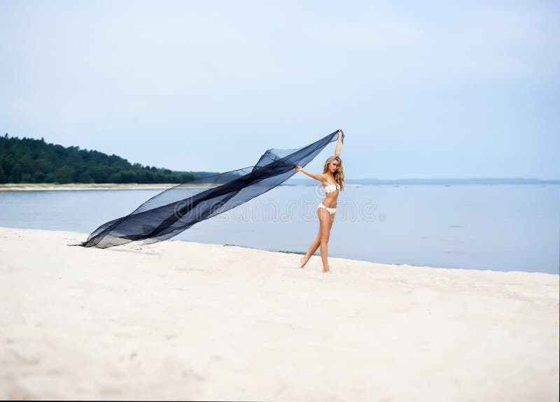 Young, fit and beautiful woman on the beach dancing