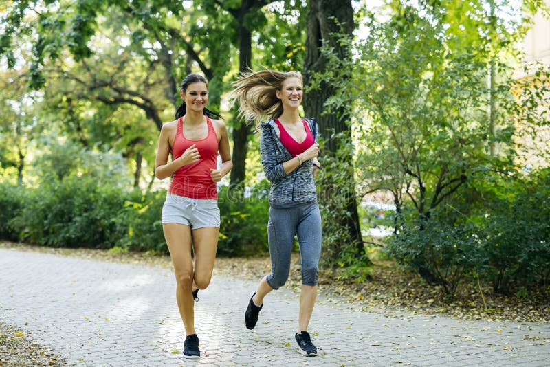 Young fit women jogging outdoors stock photos