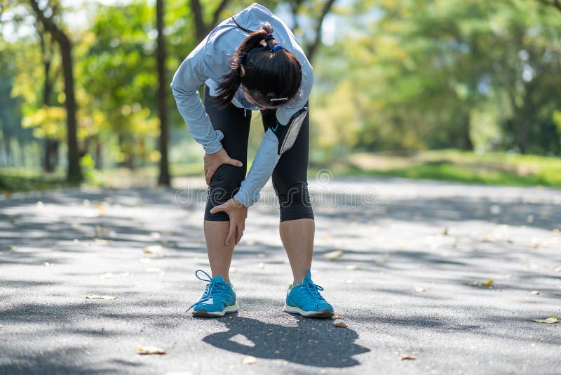 Young fitness woman holding his sports leg injury, muscle painful during training. Asian runner having calf ache and problem after