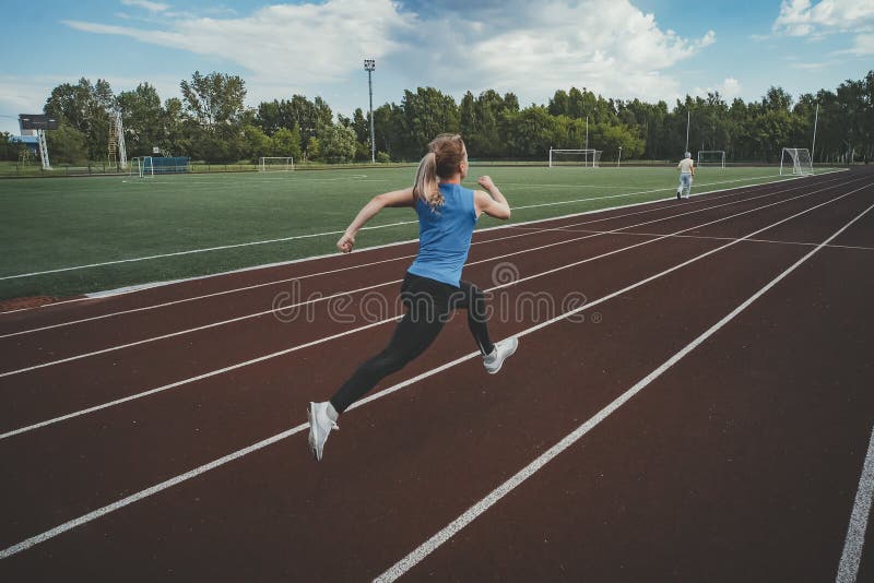 Young fitness woman runner running on stadium track. Athletics at the stadium. royalty free stock images Young fitness woman runner running on stadium track. Athletics at the stadium. royalty free stock images