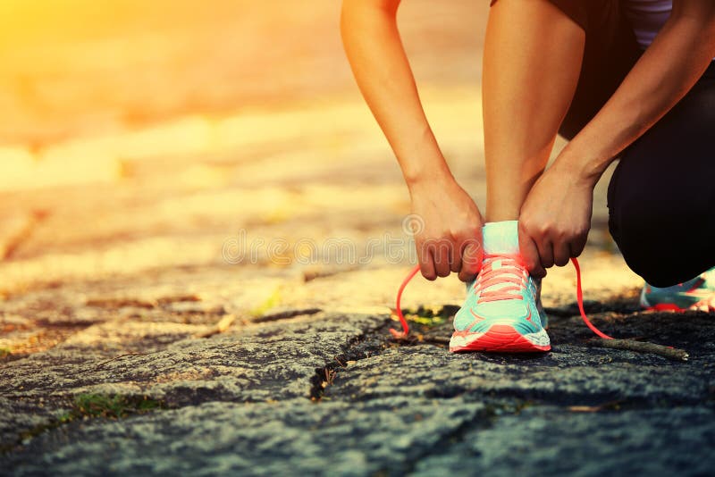 Young fitness woman tying shoelaces