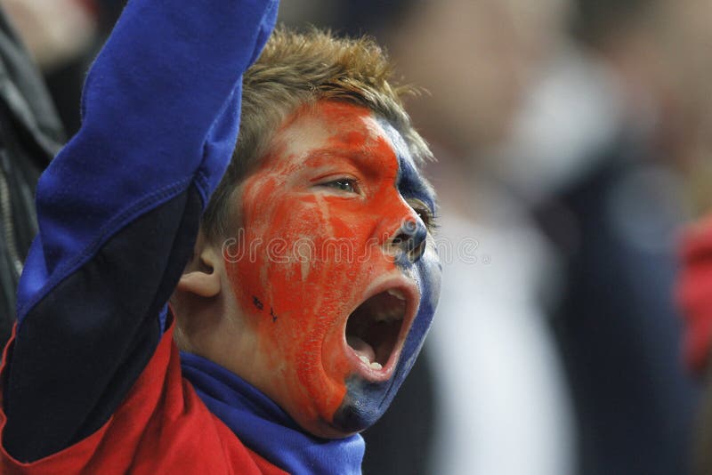 Young football fan with painted face cheering