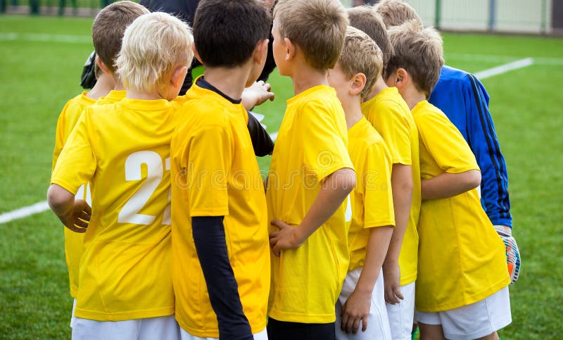 Young football soccer players with coach. Coach motivate children sports team royalty free stock images Young football soccer players with coach. Coach motivate children sports team royalty free stock images