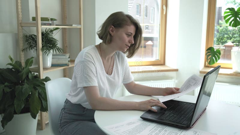 Pretty caucasian lady working at laptop computer, looking at screen, laughing stock video