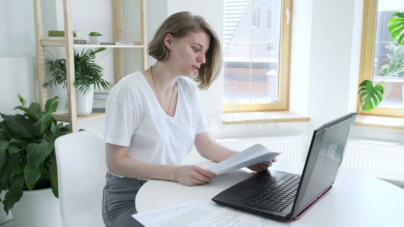 Pretty caucasian lady working at laptop computer, looking at screen, laughing stock video footage