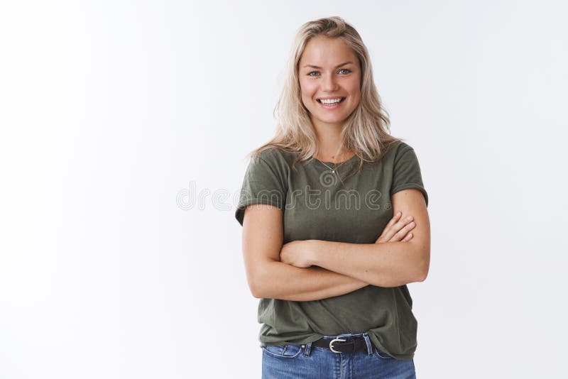 Young friendly-looking attractive mother talking other moms during b-day party crossing arms over body and smiling stock photo Young friendly-looking attractive mother talking other moms during b-day party crossing arms over body and smiling stock photo
