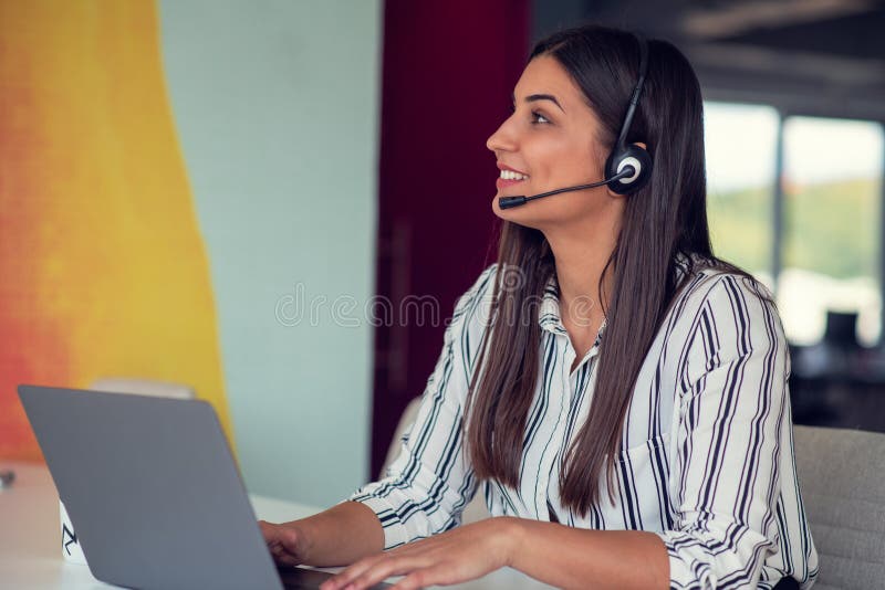Young Friendly Operator Woman Agent with Headsets Working in a Call