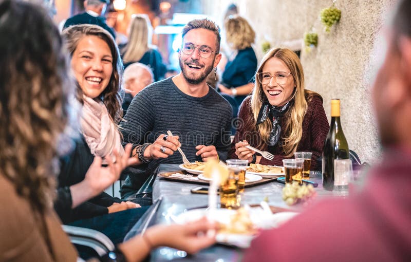 Young friends having fun drinking white wine at street food festival - Happy people eating local plates at open air restaurant stock photos Young friends having fun drinking white wine at street food festival - Happy people eating local plates at open air restaurant stock photos