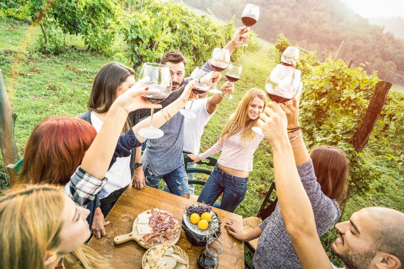 Junge Freunde, die Spaß im freien trinken Rotwein Gläser Glückliche Menschen Essen, saisonale Lebensmittel bei der Ernte Bauernhaus, Weinberg, Weingut.