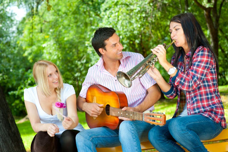 Young friends play the guitar and trumpet