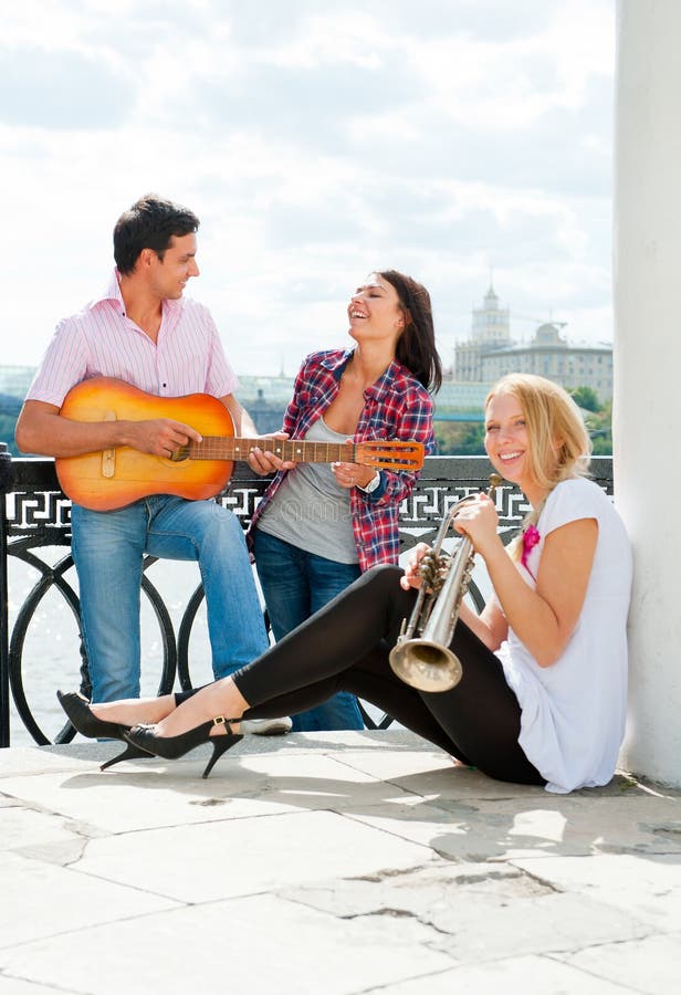 Young friends play the guitar and trumpet