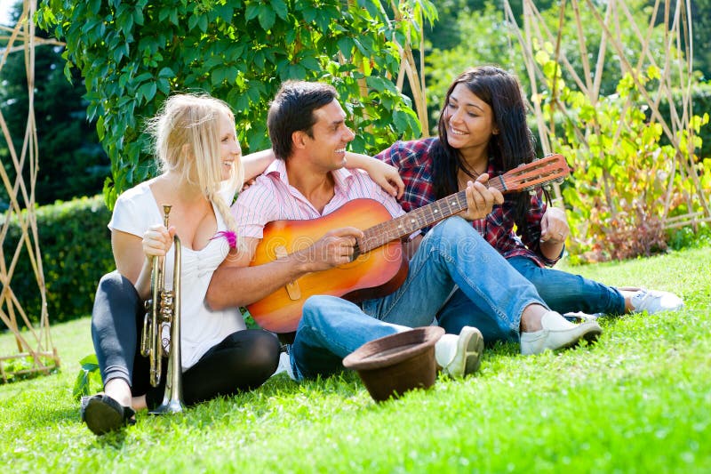 Young friends play the guitar and trumpet