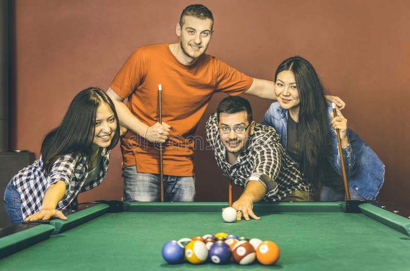 Young friends playing pool at billiard table saloon - Happy friendship stock image Young friends playing pool at billiard table saloon - Happy friendship stock image