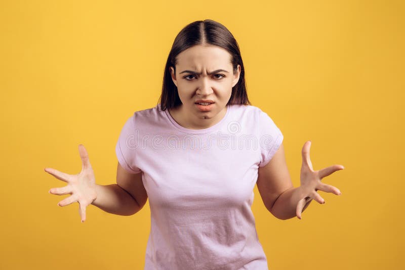 Young frowning girl expresses feeling. Of irritation. Female emotions. Isolated on yellow background royalty free stock photos Young frowning girl expresses feeling. Of irritation. Female emotions. Isolated on yellow background royalty free stock photos