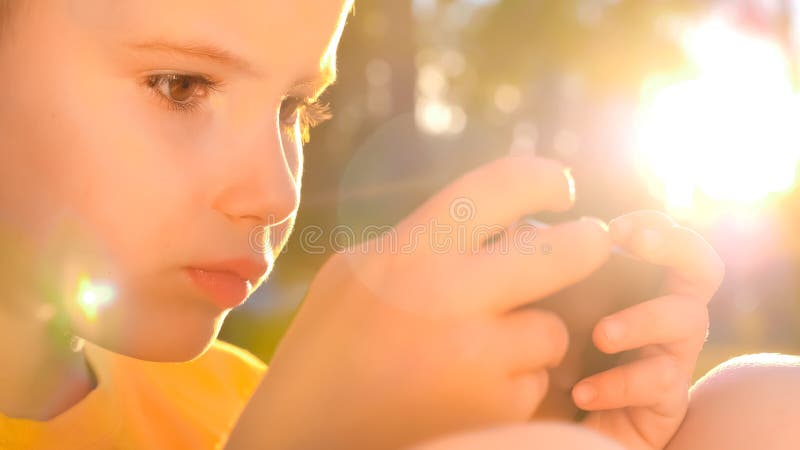 Young gamer playing game on mobile. Kid with smartphone smartphone. Children and Technology. Online game, mobile app. Little boy child kid playing games on stock photos Young gamer playing game on mobile. Kid with smartphone smartphone. Children and Technology. Online game, mobile app. Little boy child kid playing games on stock photos