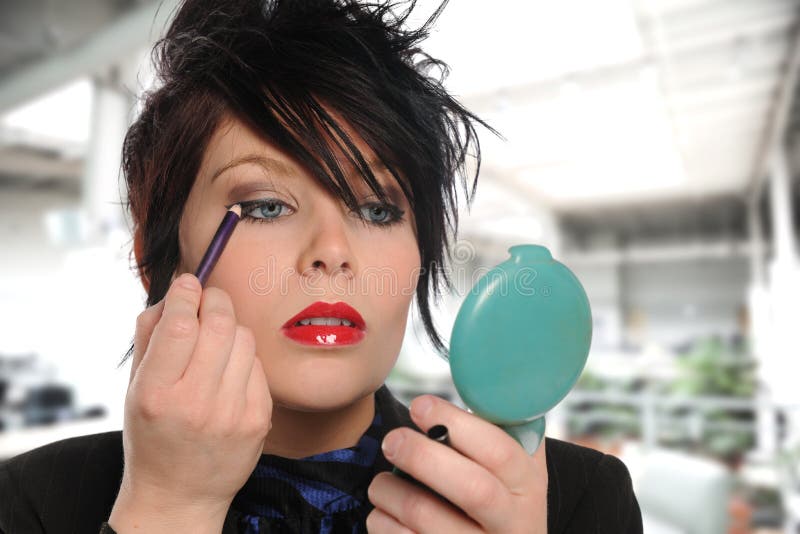 Young girl applying make up