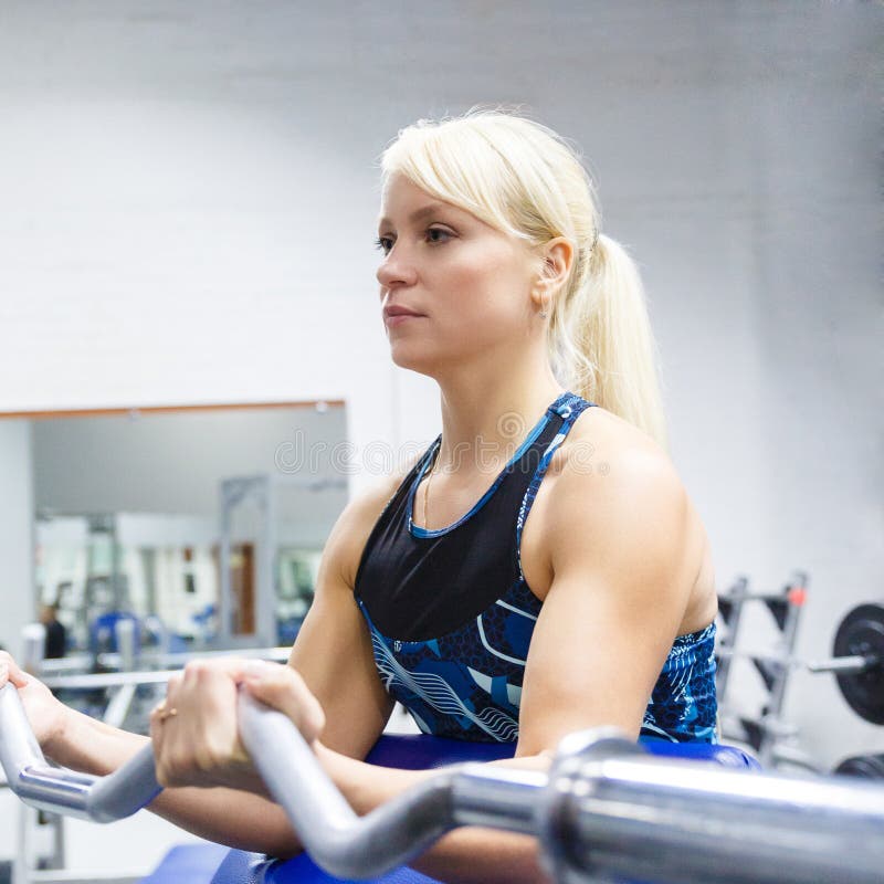 A young girl athlete with blond hair performs an exercise with a curved bar in the gym royalty free stock images A young girl athlete with blond hair performs an exercise with a curved bar in the gym royalty free stock images