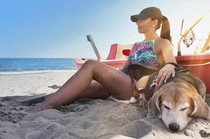 Young girl on the beach with the beagle dog