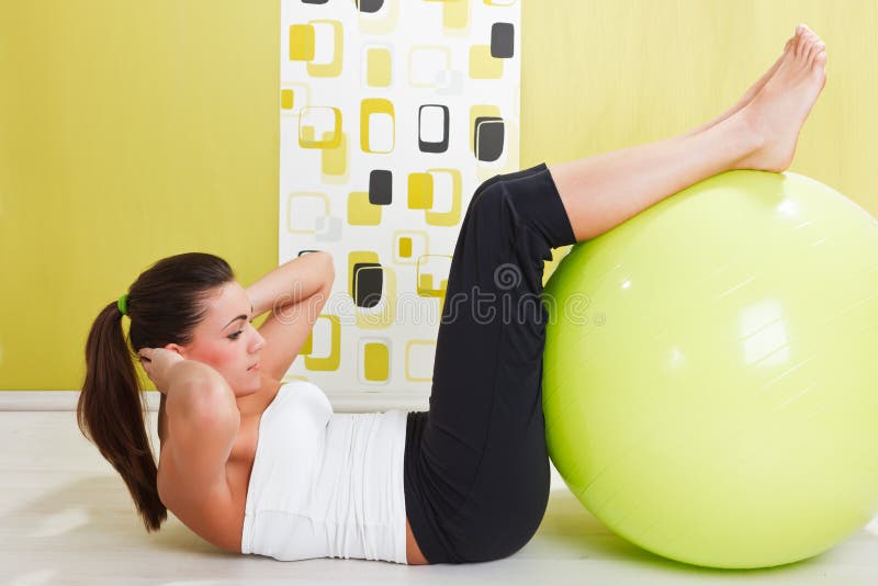 Young girl behooves gym exercise with ball