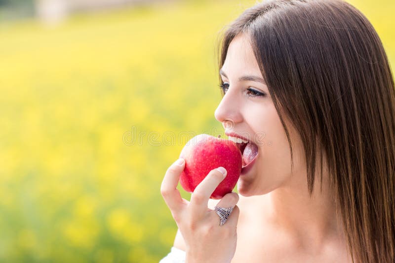 young-girl-biting-red-apple-outdoors-close-up-face-shot-woman-91726634.jpg