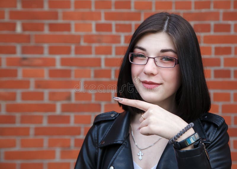 Young girl in black jacket points to the side