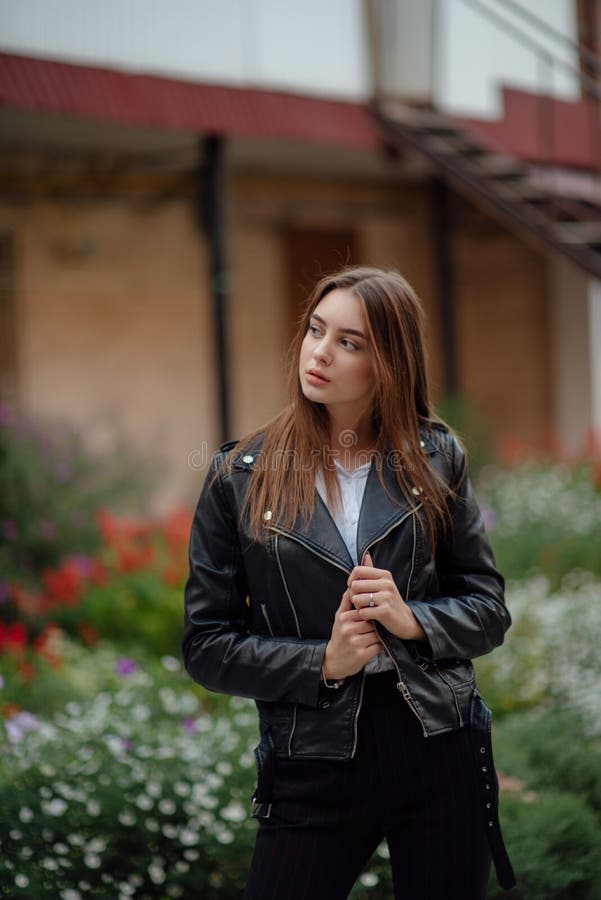 Young Girl in a Black Leather Jacket Stands on the Background of a City ...