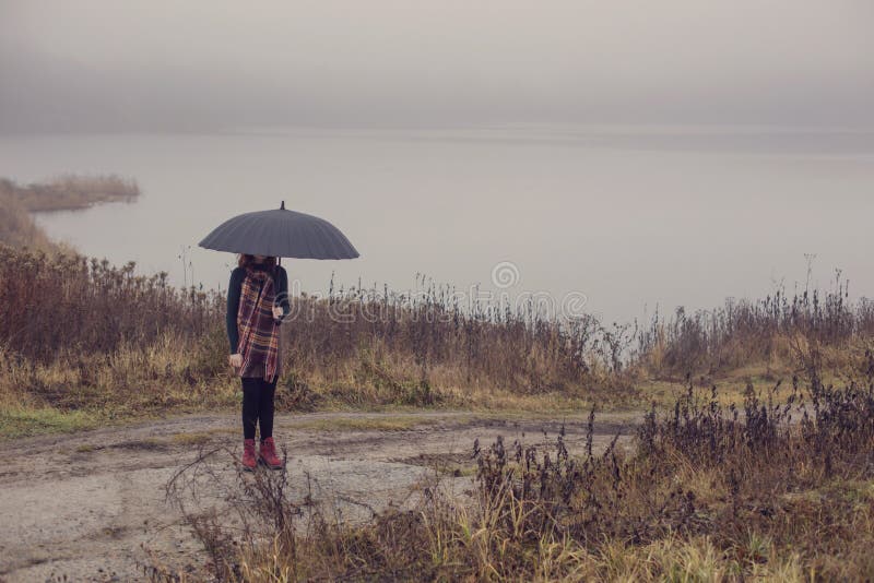 Girl with black umbrella on background dark foogy lake royalty free stock images Girl with black umbrella on background dark foogy lake royalty free stock images
