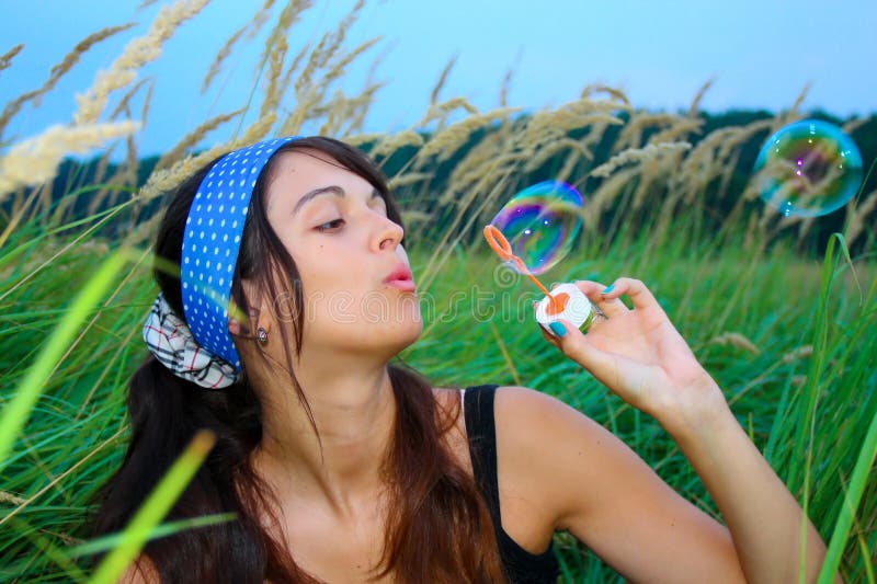 Young girl blowing soap bubbles