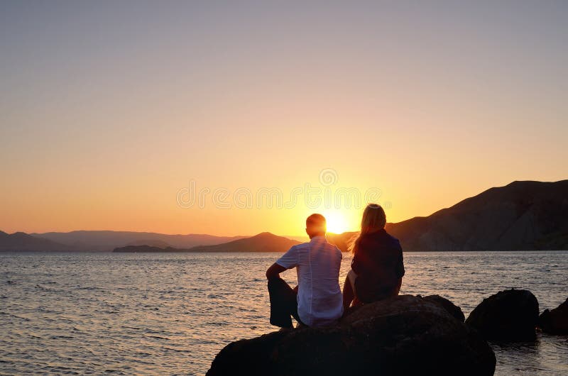 Young girl and boy sitting on a rock