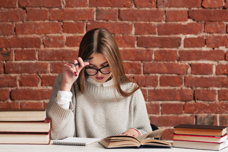 Young girl carefully reading material at library