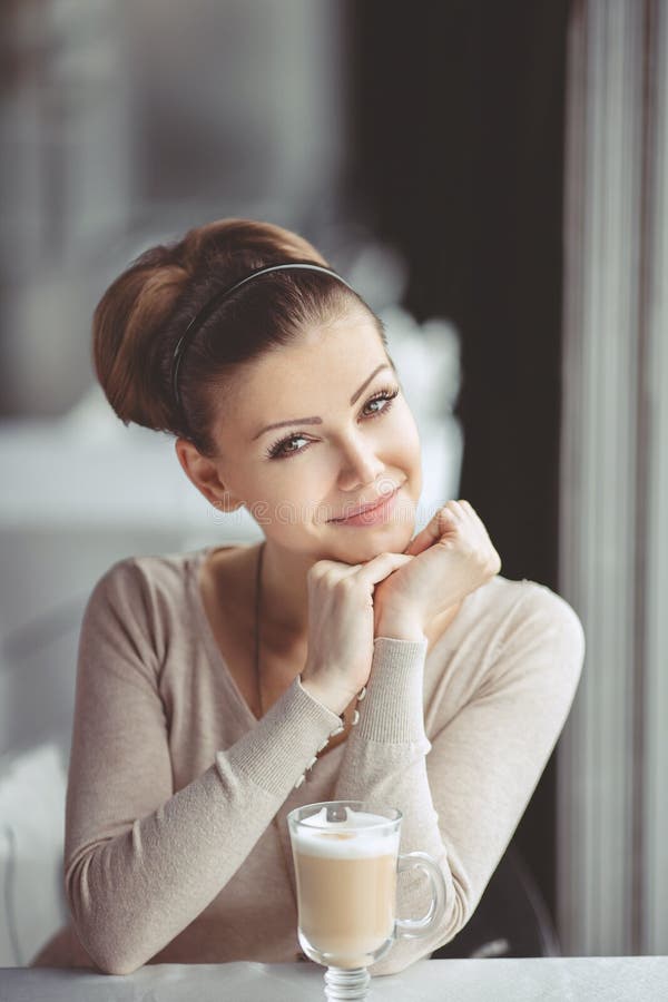 Young girl with a cup of coffee. Focus on the eyes.