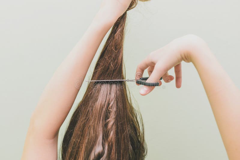 A Young Girl Decided To Cut Her Hair. in the Hands of Holding a Bunch of  Hair and Scissors. Long Brown Hair Stock Image - Image of depressed,  donate: 141023551