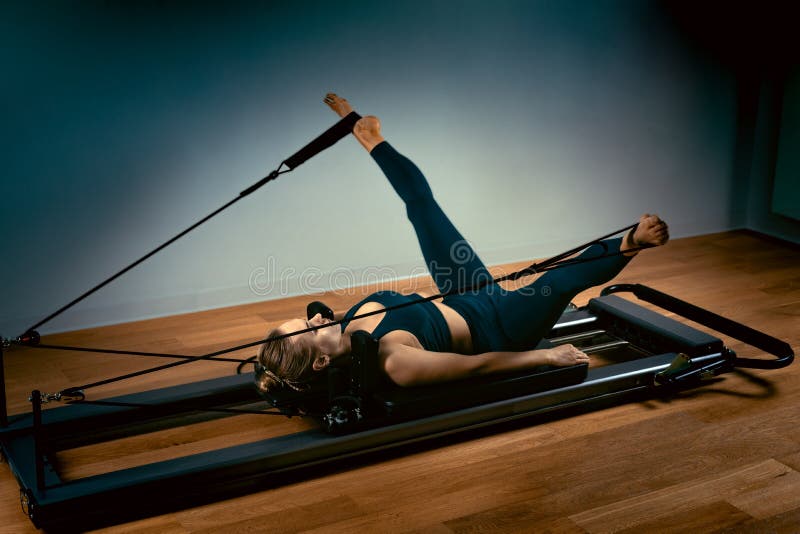 A young girl does Pilates exercises with a bed - Stock Photo